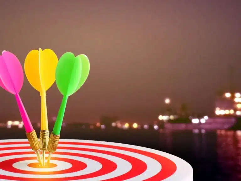 A red liner dartboard with colorful dart lighting show in the background.