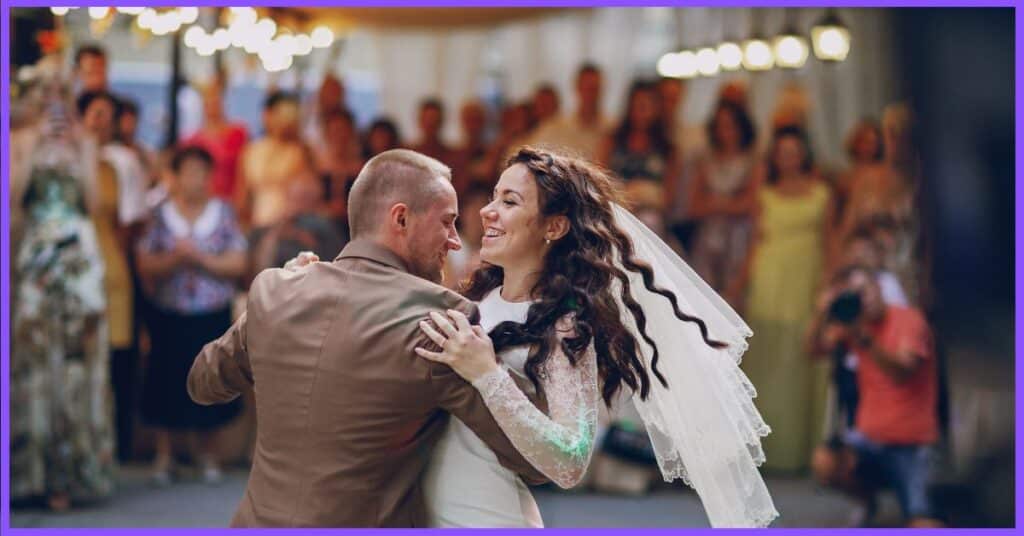 A joyous wedding couple gracefully dancing during their ceremony, surrounded by friends and family.