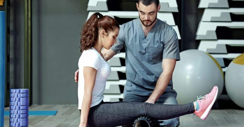 A therapist helping a patient with an exercise in a gym setting.(Do They Check Your Private Parts in a Sports Physical)