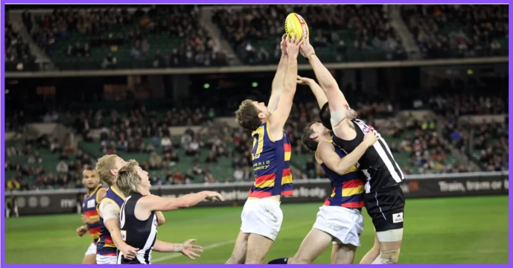 Two Australian rules football players jumping up to catch the ball.