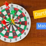 A dartboard with multiple colorful darts stuck in it, hanging on a wooden wall. Two labels reading “Dartboard” and “Material” are present beside the dartboard.